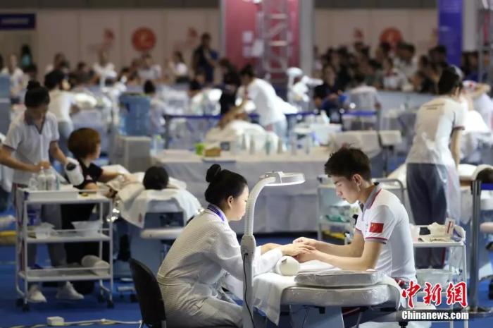 資料圖：2018中國技能大賽現場，美容師正在給體驗者做指甲。 張亨偉攝